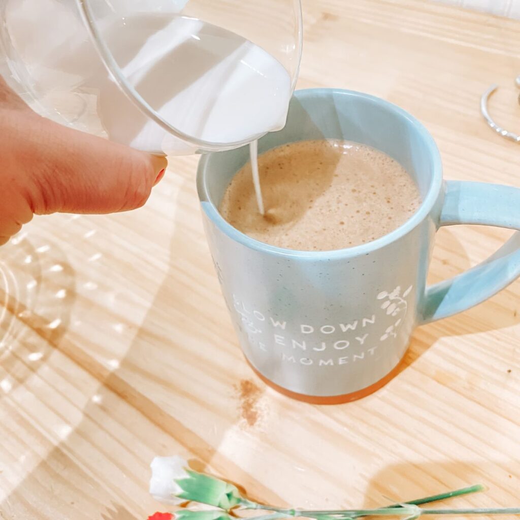 pouring milk into coffee mug to make copycat starbucks mocha latte